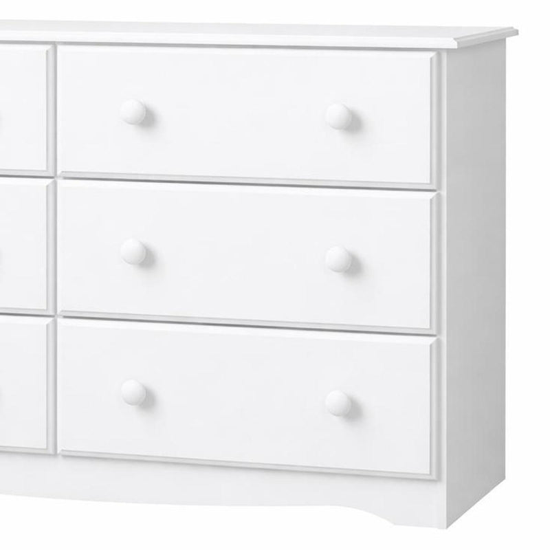 White solid wood six-drawer dresser, close-up of three drawer fronts and round knobs