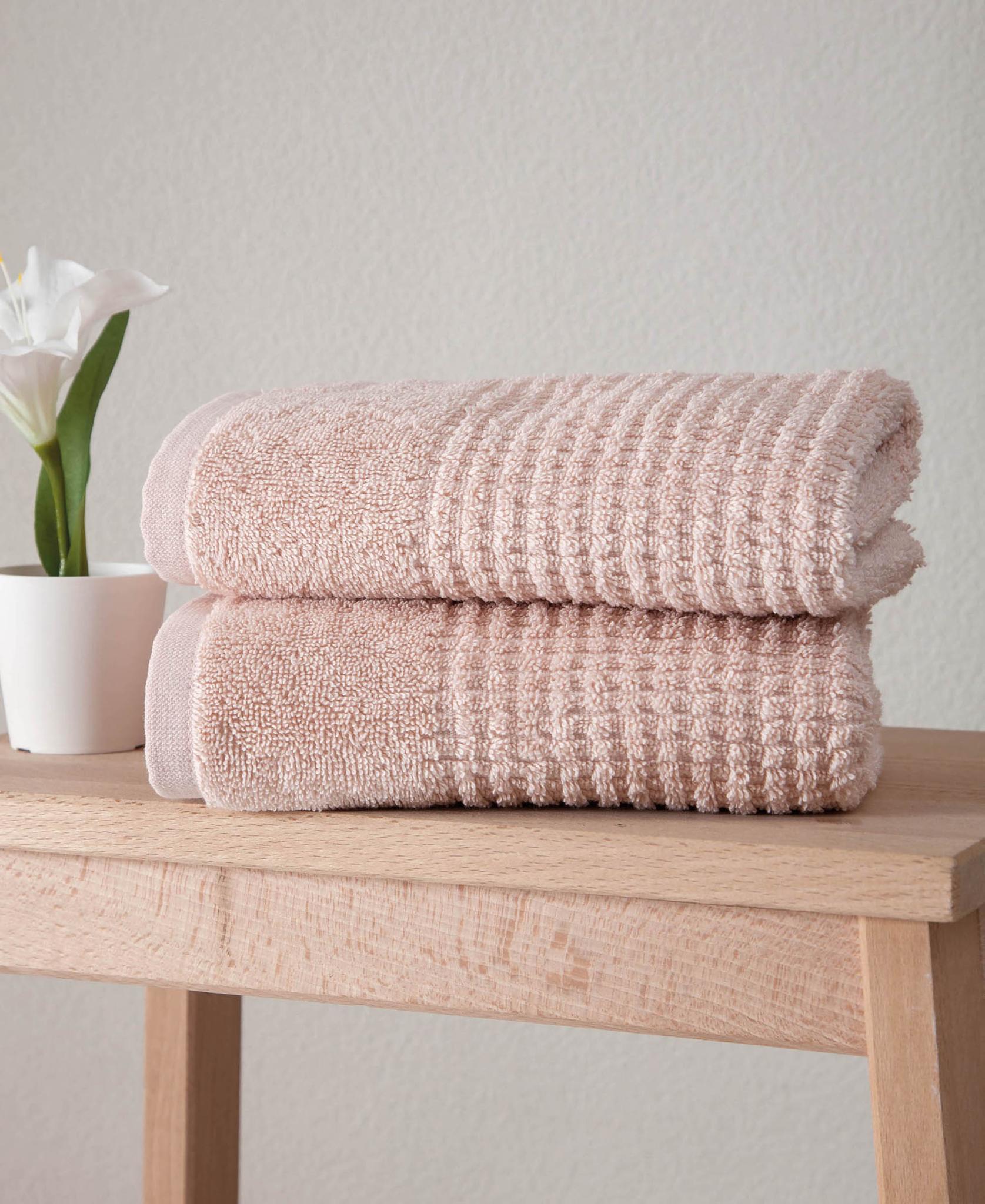 Set of two pink Turkish cotton hand towels stacked, textured waffle weave, folded
