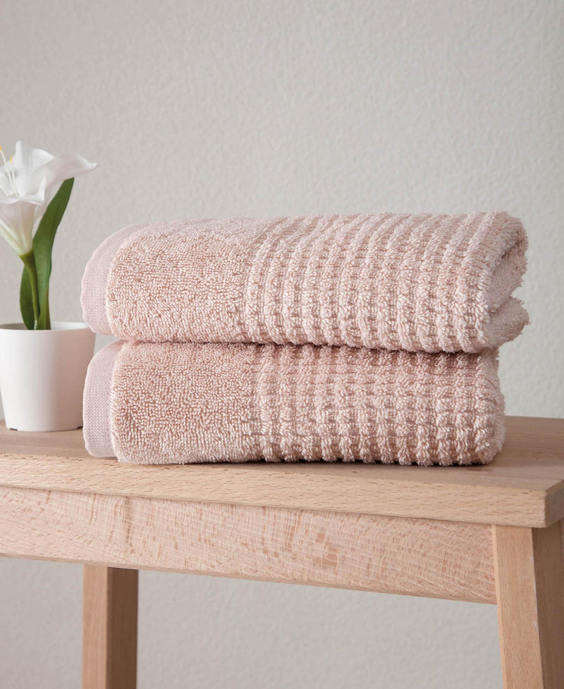 Set of two pink Turkish cotton hand towels stacked, textured waffle weave, folded