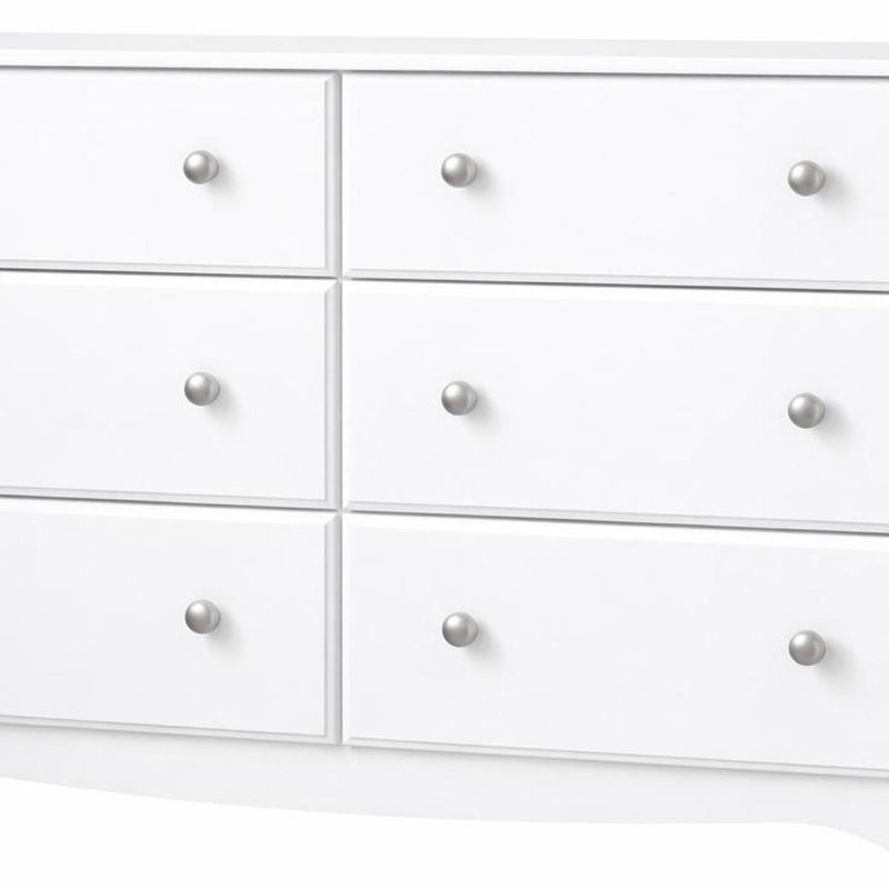 Close-up of white dresser drawers with round silver knobs, six-drawer layout