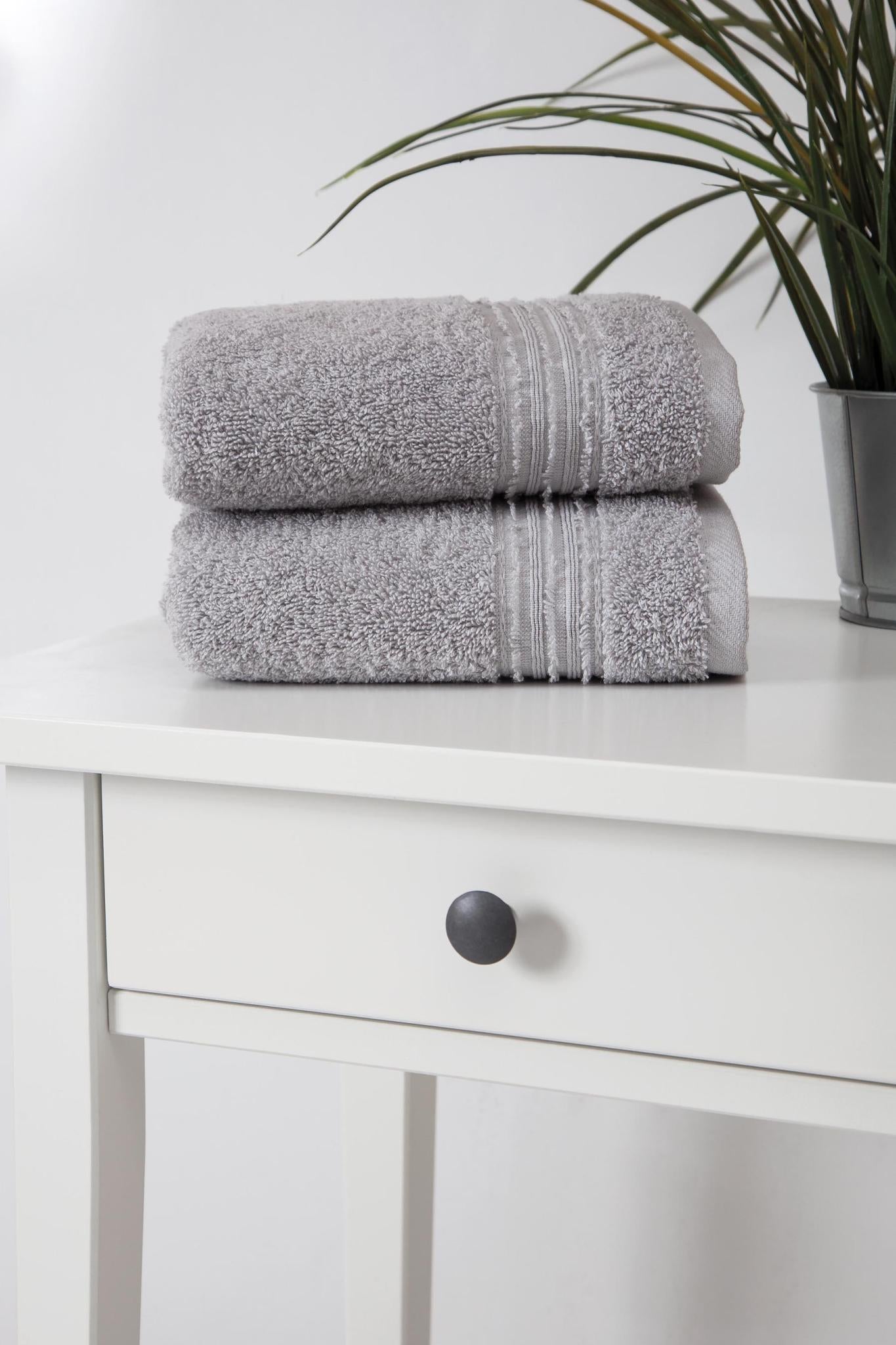 Light gray Turkish cotton hand towels stacked, textured terry loops with striped border