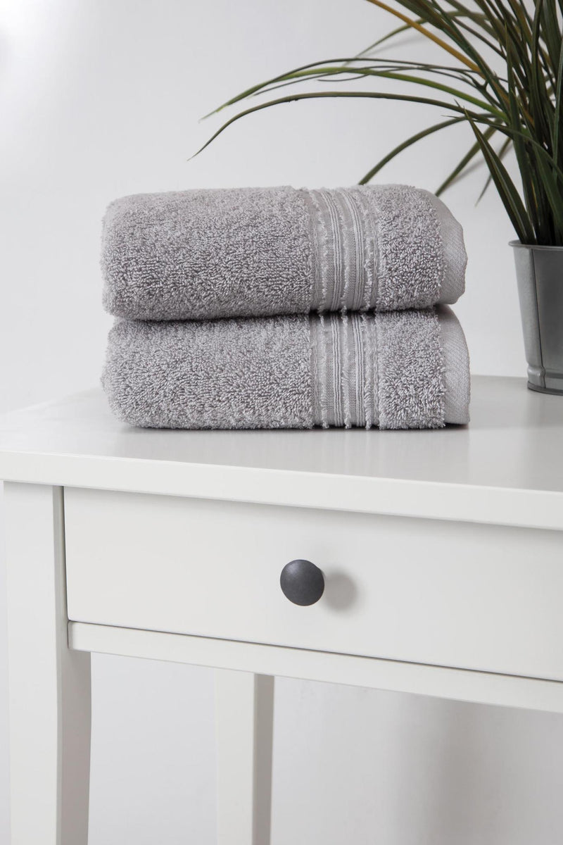 Light gray Turkish cotton hand towels stacked, textured terry loops with striped border