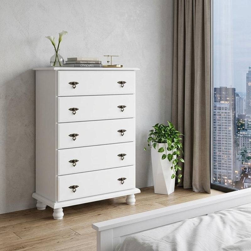 White five-drawer dresser with ornate metal knobs, shown in a room corner.