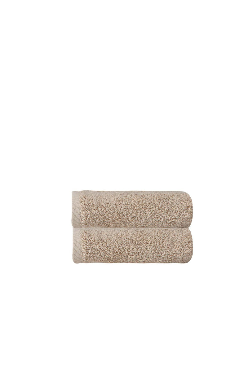 Beige hand towels, neatly folded plush terry with looped pile