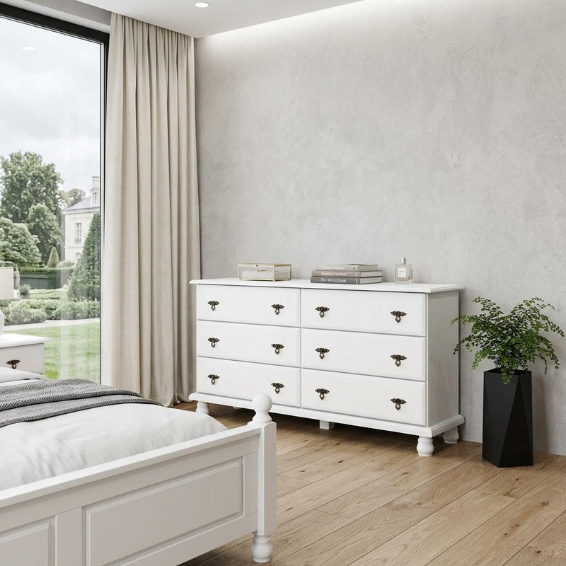 White six-drawer dresser with black knob hardware and paneled cabinet base