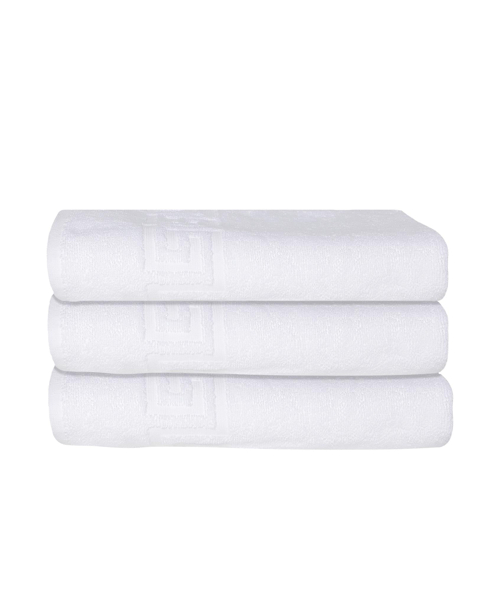 Stack of three white Turkish cotton bath towels with Greek key border visible on ends