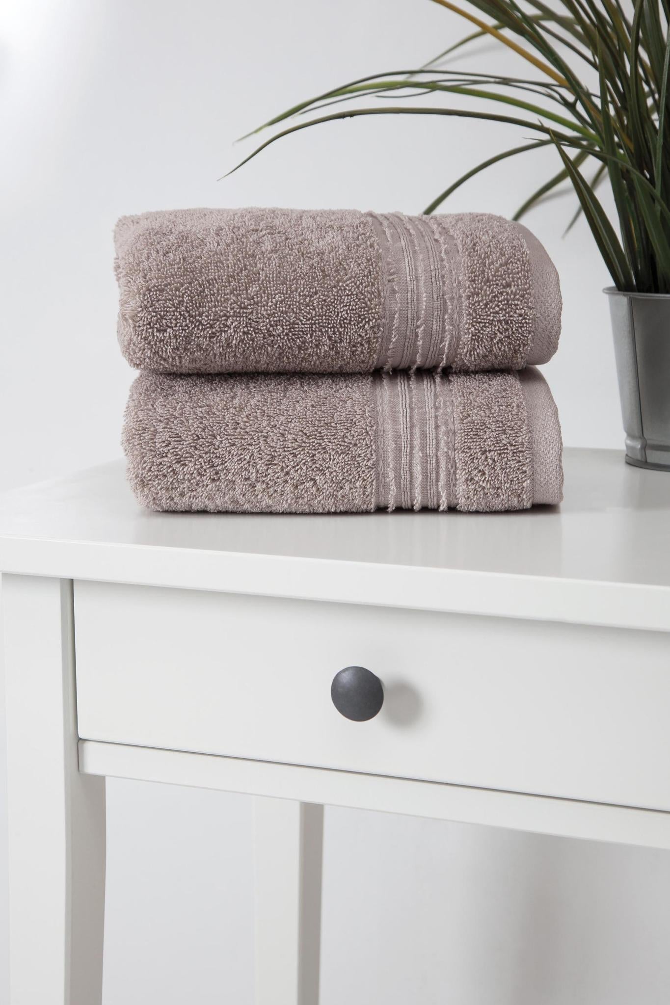 Stacked light brown Turkish hand towels with striped bands, terry texture