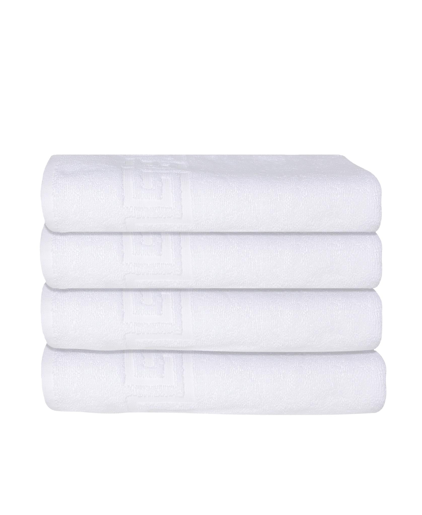 Stack of white Turkish cotton bath towels with embossed Greek key pattern