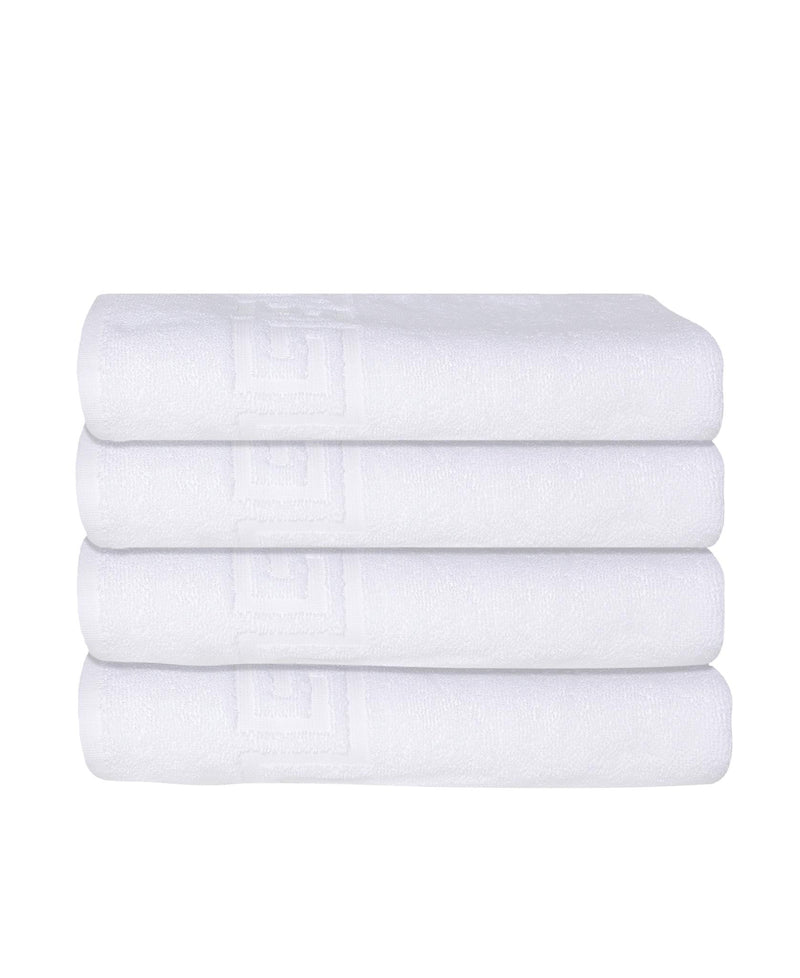 Stack of white Turkish cotton bath towels with embossed Greek key pattern