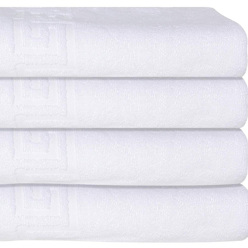 White Turkish cotton bath towel with embossed Greek key design, close-up