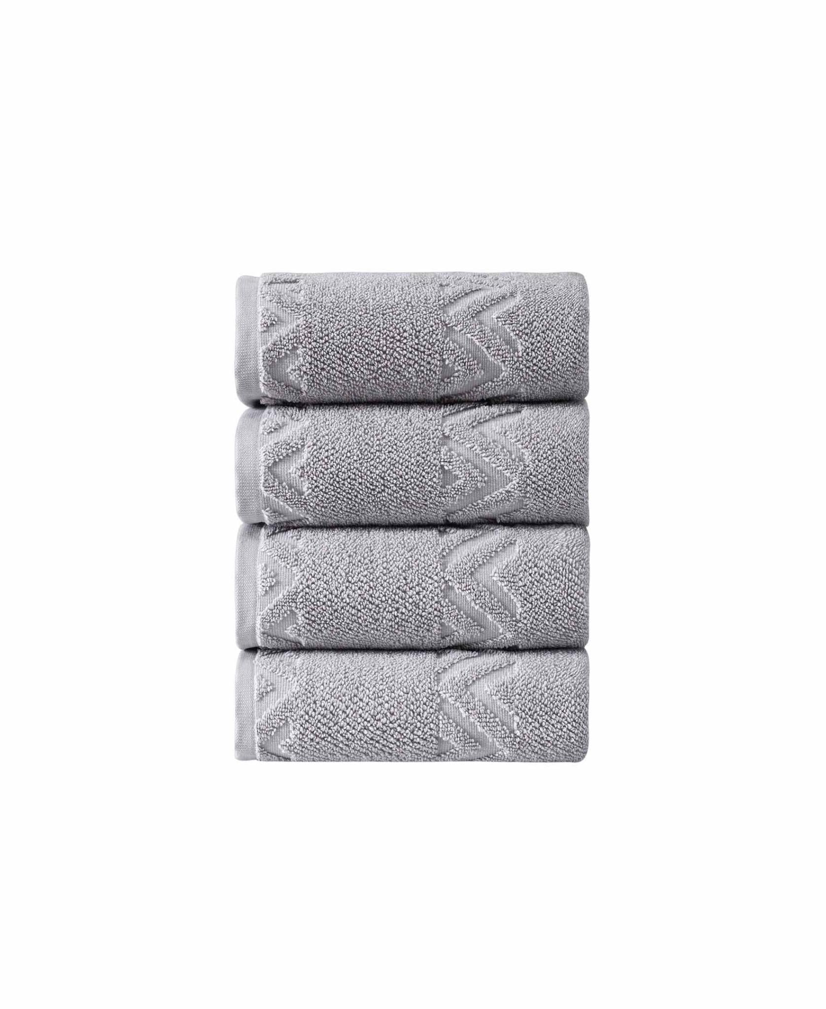 Set of four light gray Turkish cotton hand towels with zigzag geometric dobby pattern.