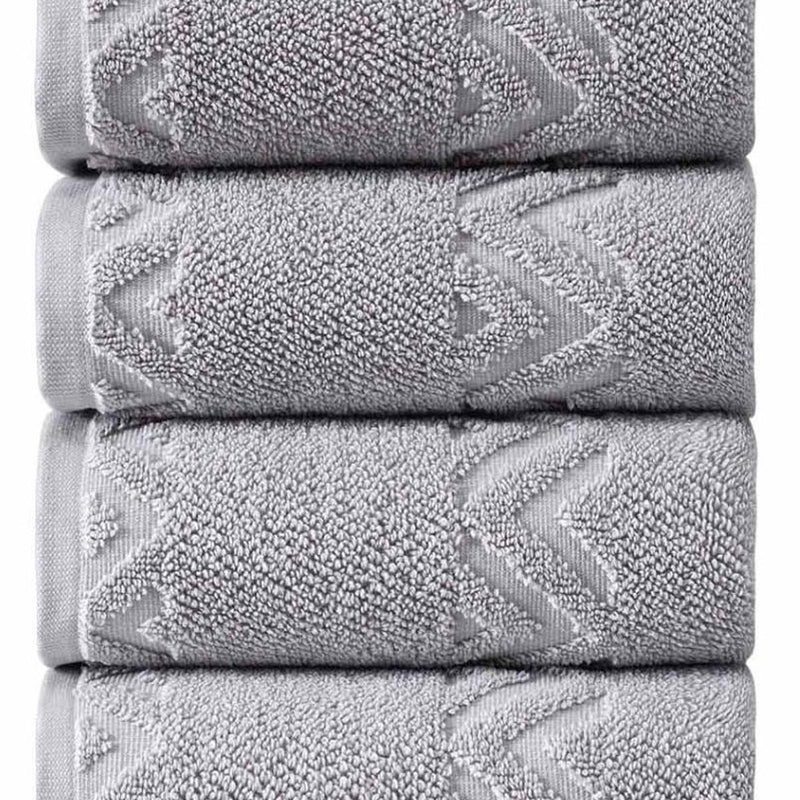 Light gray towel stack close-up showing looped texture and chevron zigzag embroidery.