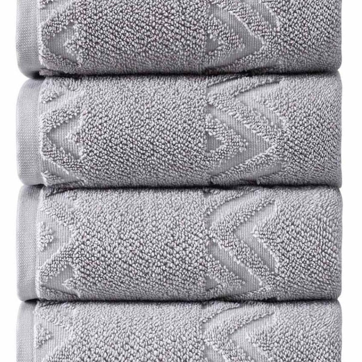 Light gray Turkish cotton hand towel stack close-up, textured zigzag geometric border.