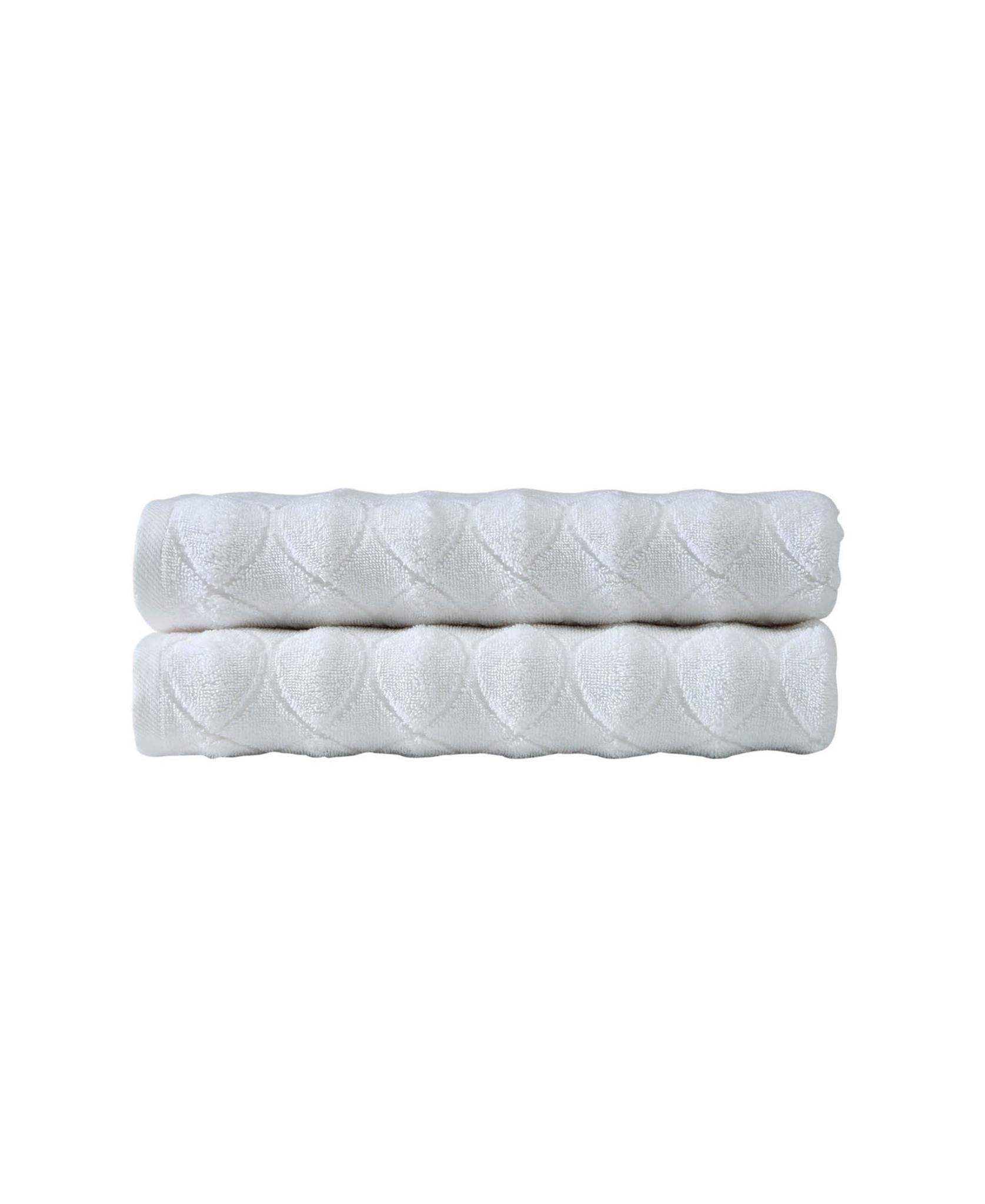 White bath towel pair with quilted diamond geometric pattern, stacked and folded