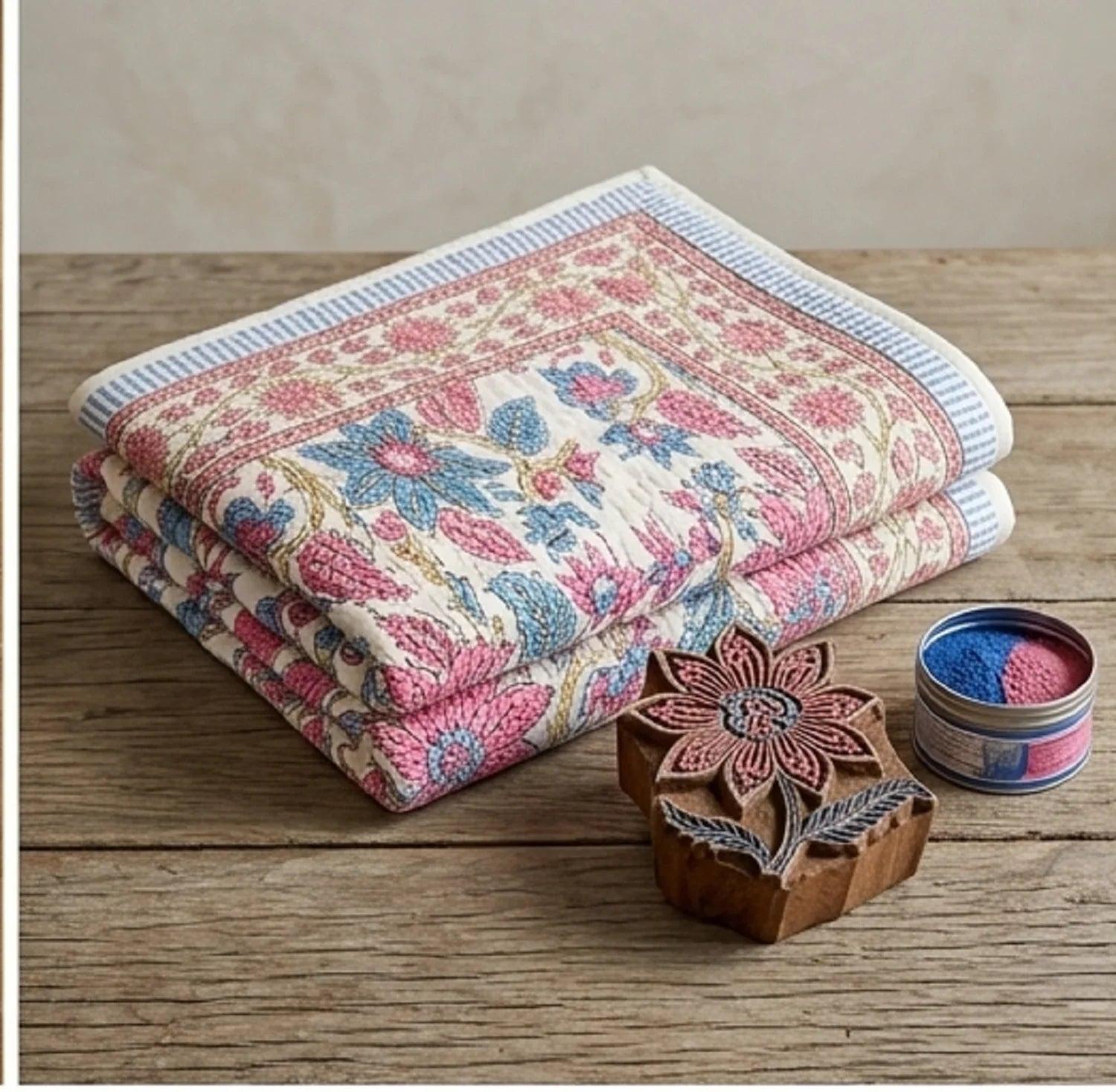 Rose floral cotton comforter with cream background and blue flower pattern, folded