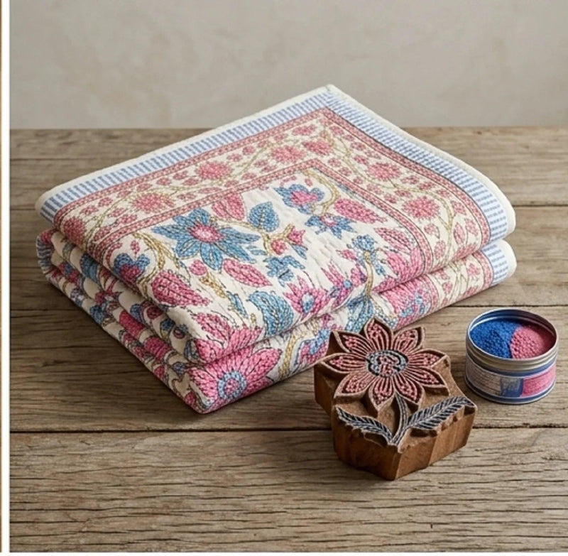 Rose floral cotton comforter with cream background and blue flower pattern, folded