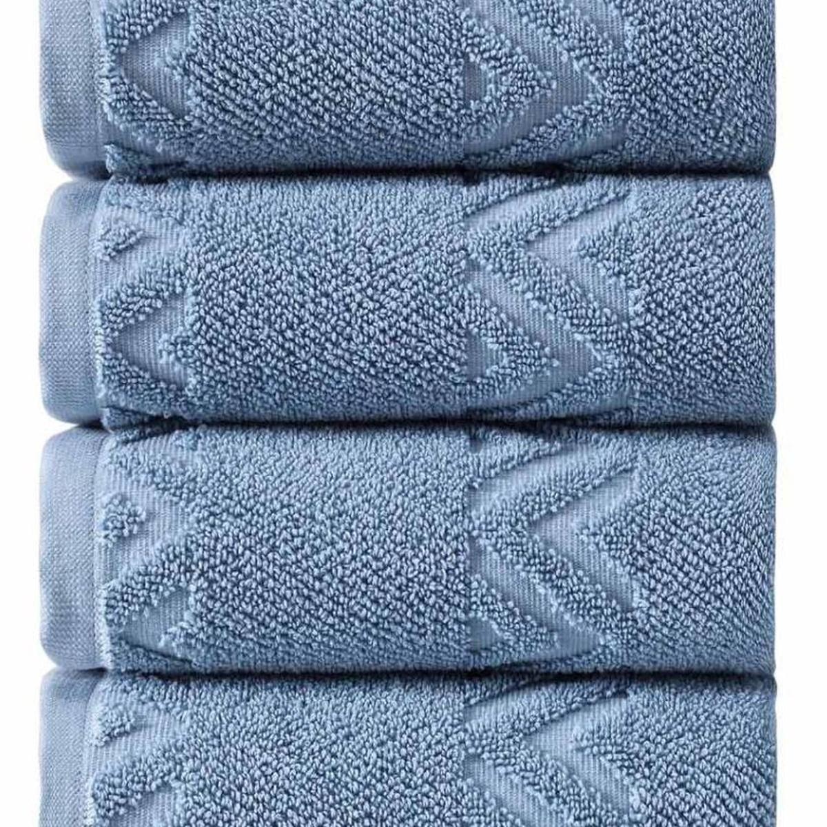 Set of four blue Turkish cotton hand towels with raised geometric chevron pattern, stacked close-up
