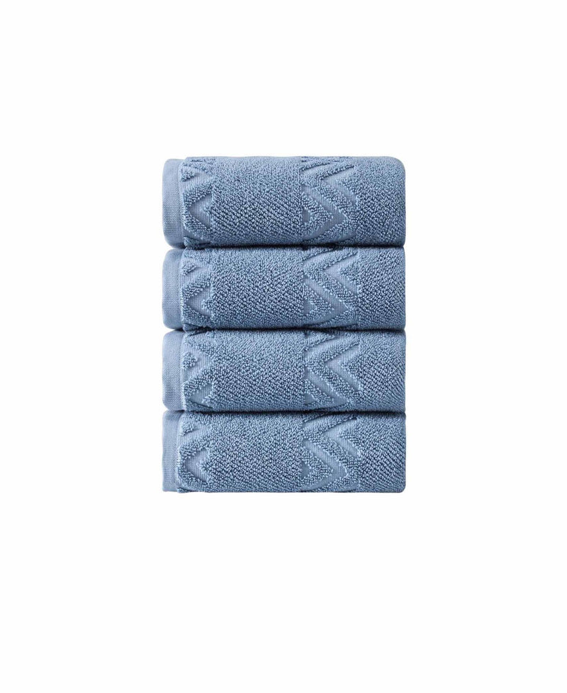 Stack of four blue Turkish cotton hand towels with geometric chevron pattern, isolated on white