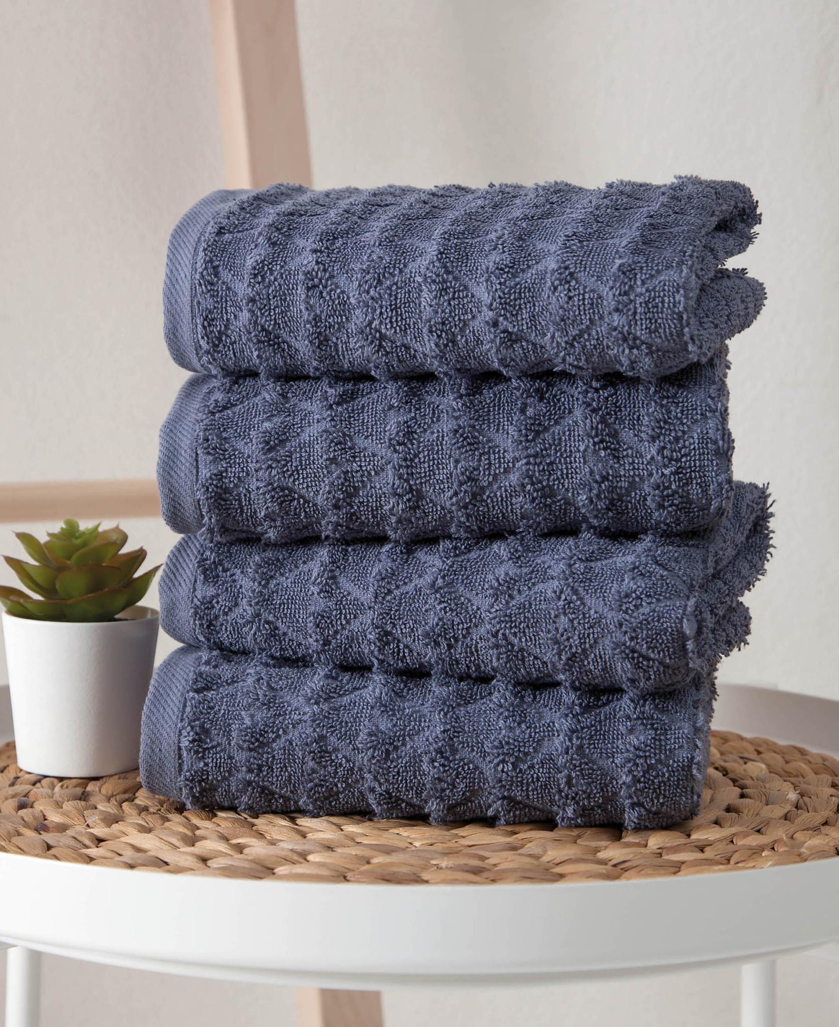 Set of four navy geometric Turkish cotton hand towels, stacked with fringe edges