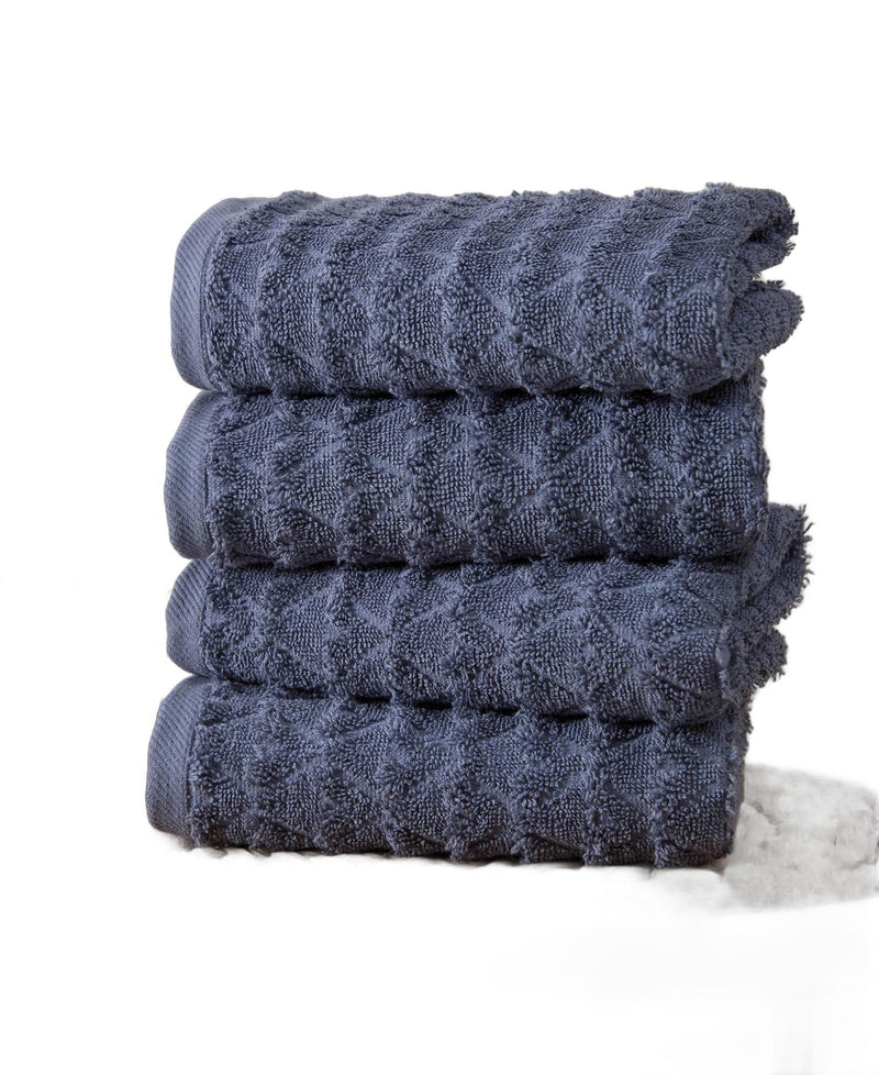 Set of four navy geometric Turkish cotton hand towels, neatly folded with fringe