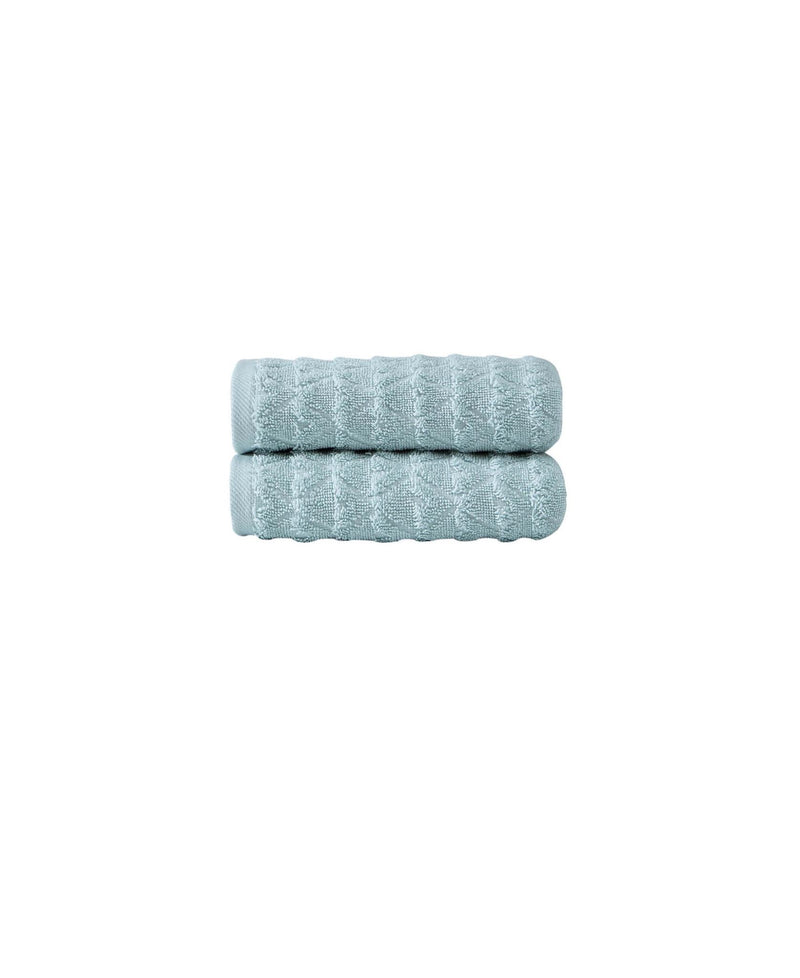 Set of two aqua Turkish hand towels, folded stack, textured geometric pattern.