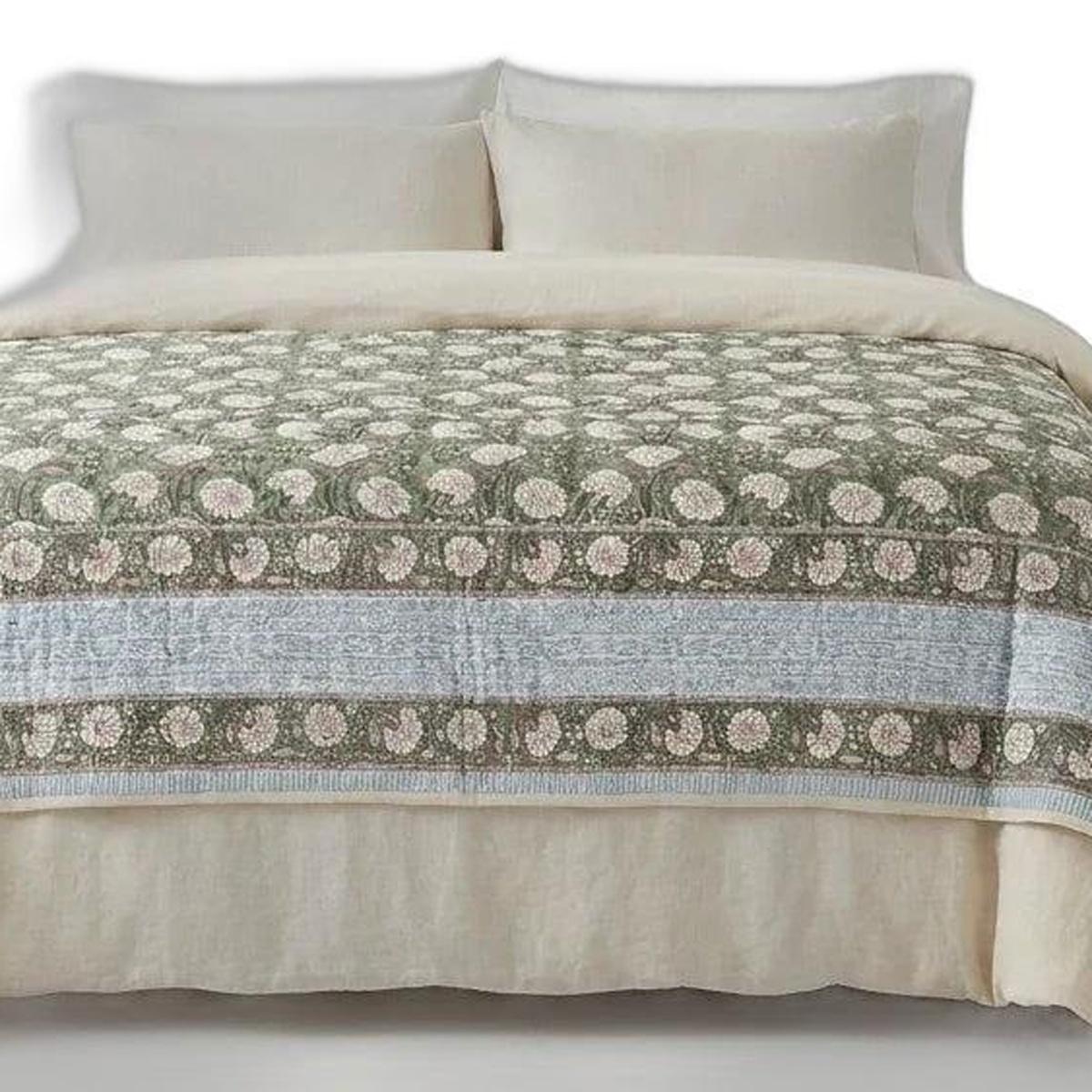 Green and cream floral cotton comforter with bordered stripe pattern on bed