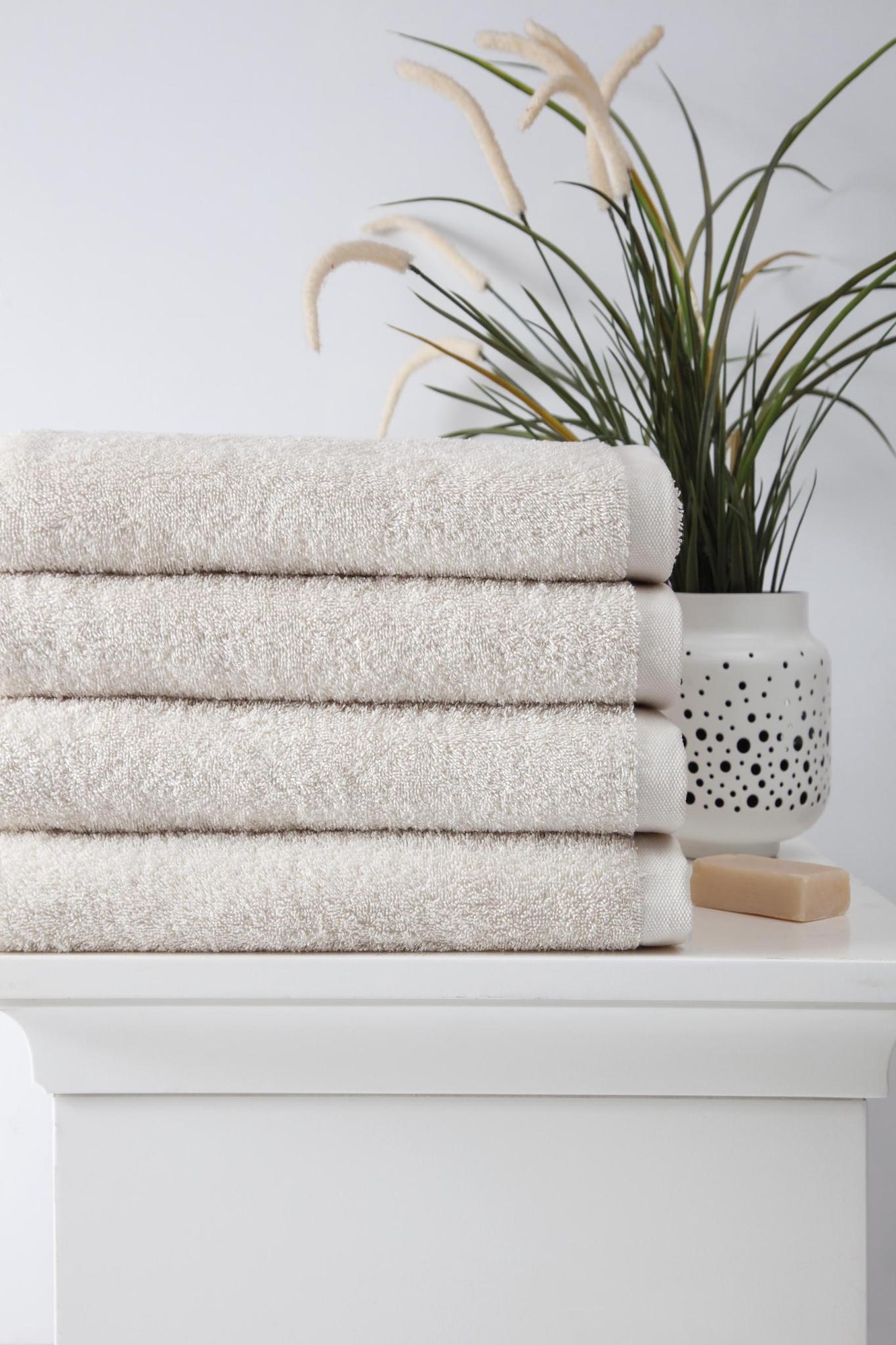 Set of four beige Turkish cotton bath towels, folded terry stack, 27 x 54 in