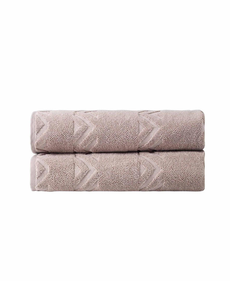 Stacked taupe bath sheets with white chevron pattern, neatly folded
