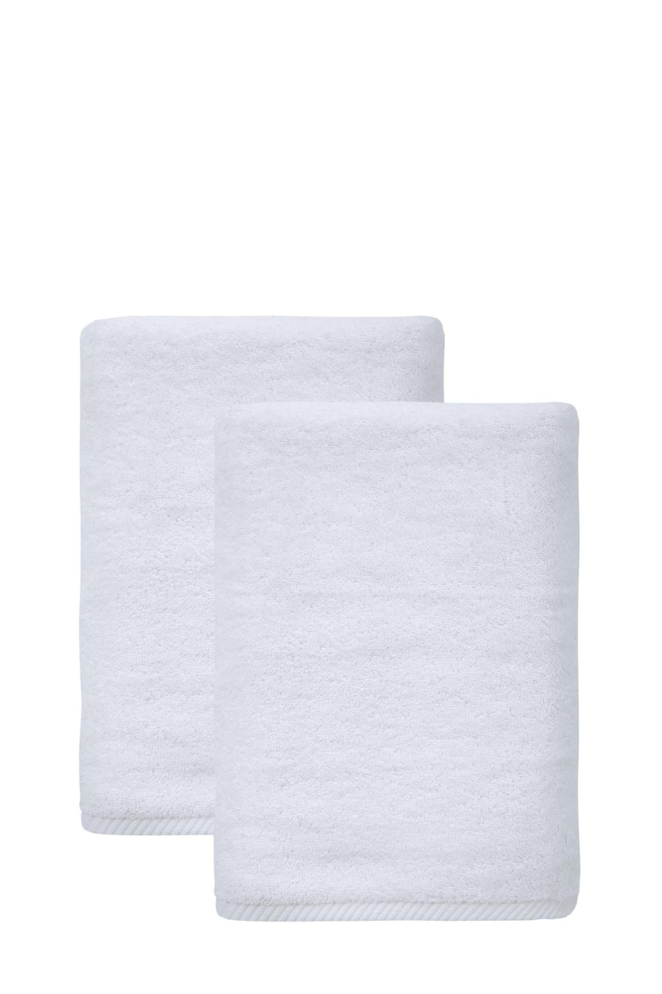 Set of two white bath towels, Turkish cotton, neatly folded and stacked