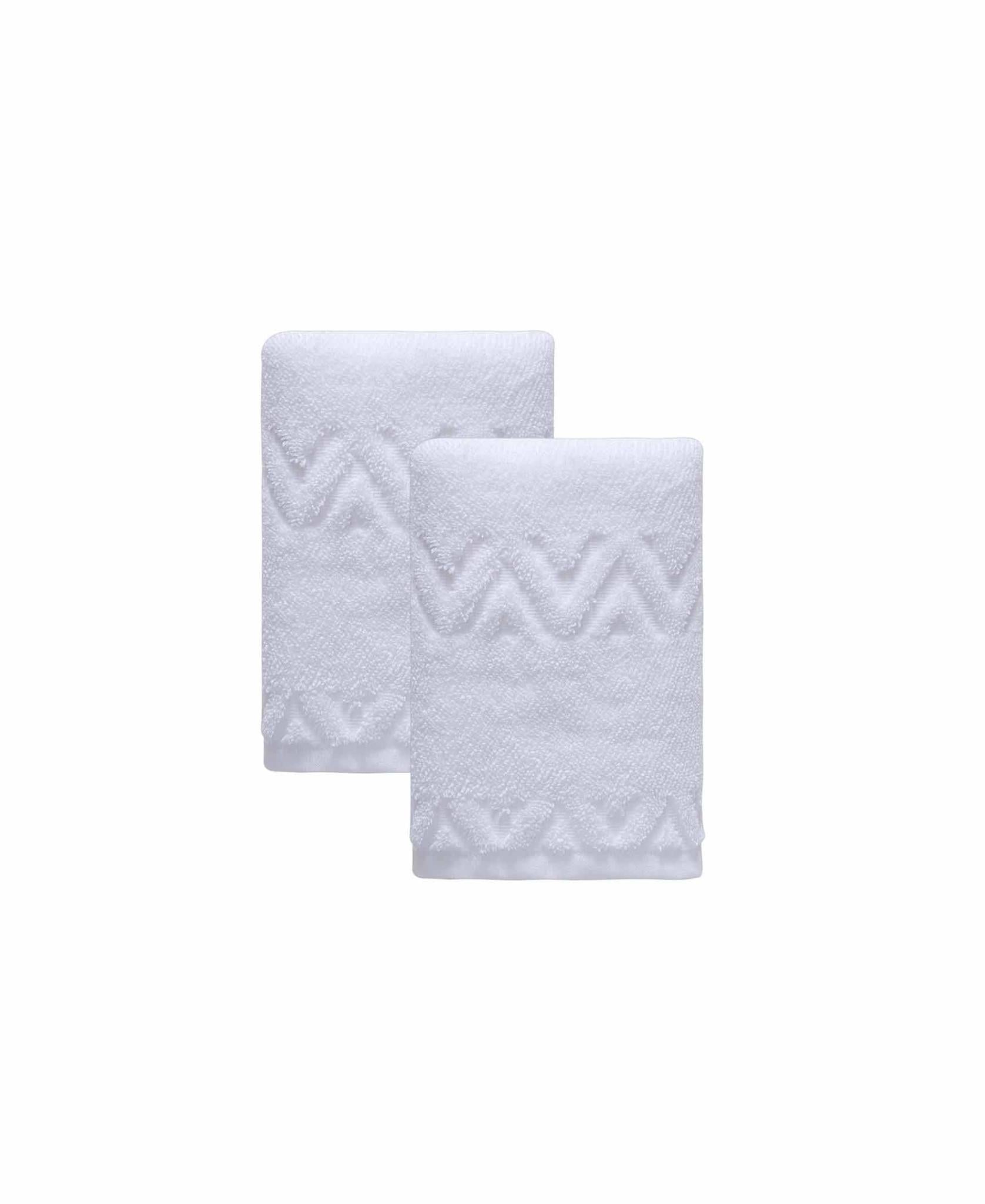 Set of two white hand towels with geometric chevron zigzag pattern, overlapping folds