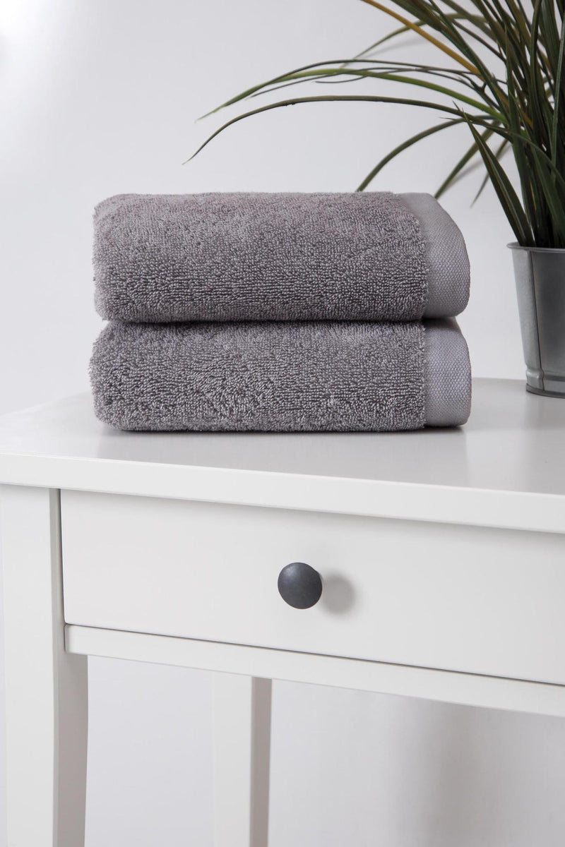 Light gray Turkish cotton hand towel pair, neatly folded terry on shelf