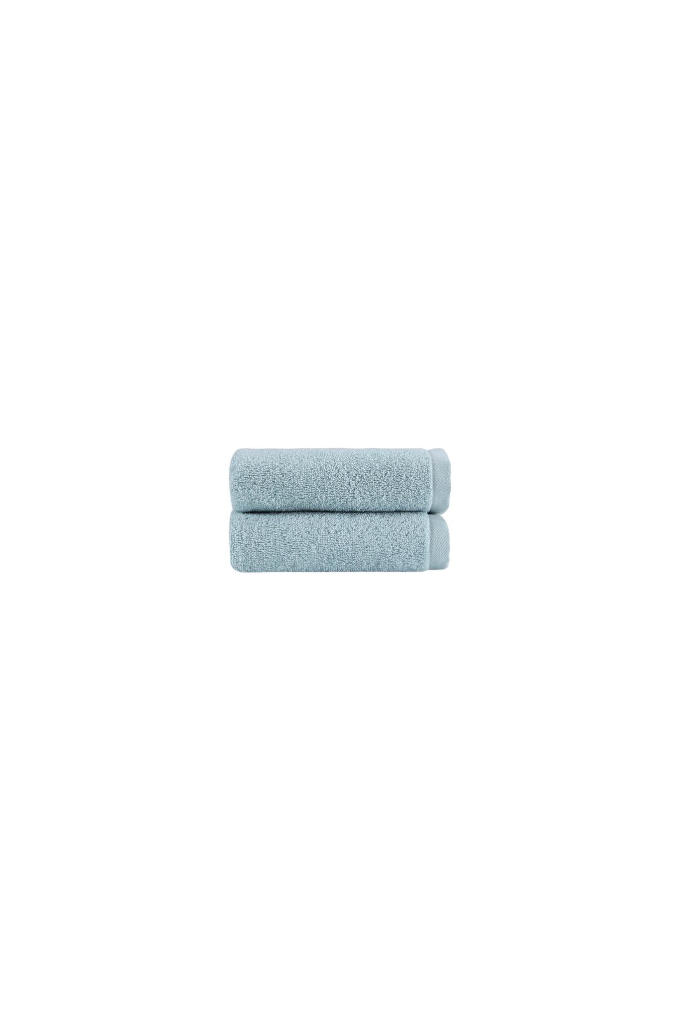 Set of two light blue hand towels, folded with soft textured terry surface.
