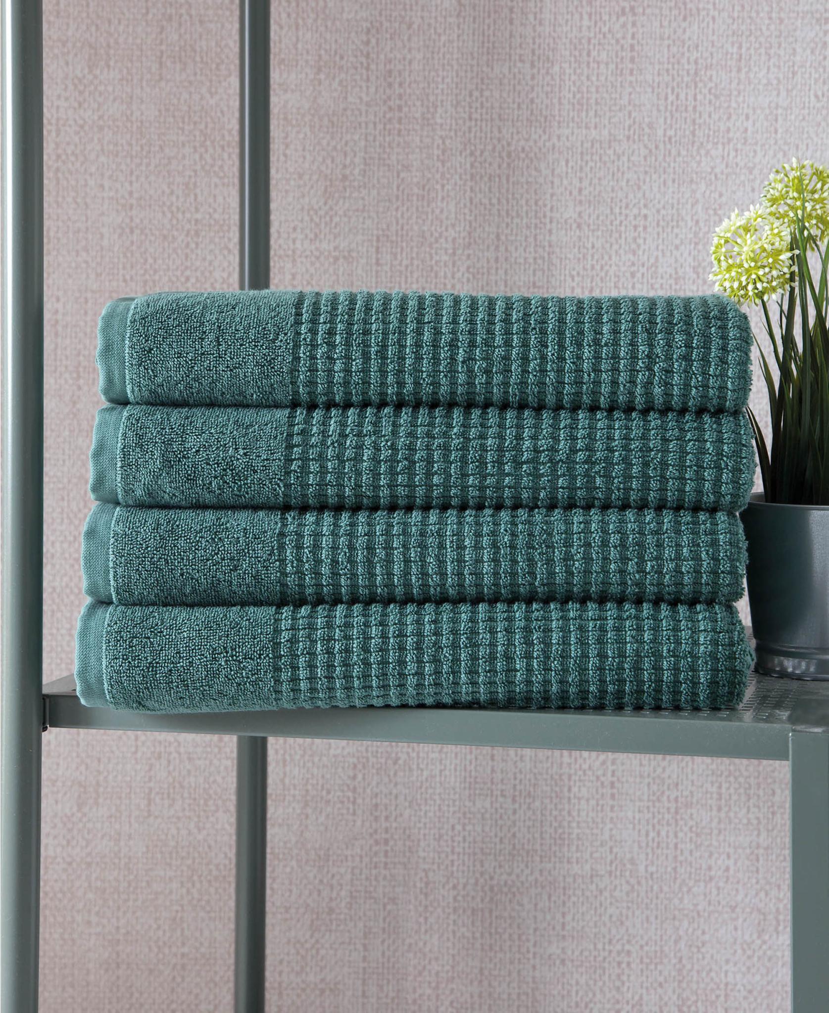 Set of four green Turkish cotton bath towels, textured waffle weave, folded stack