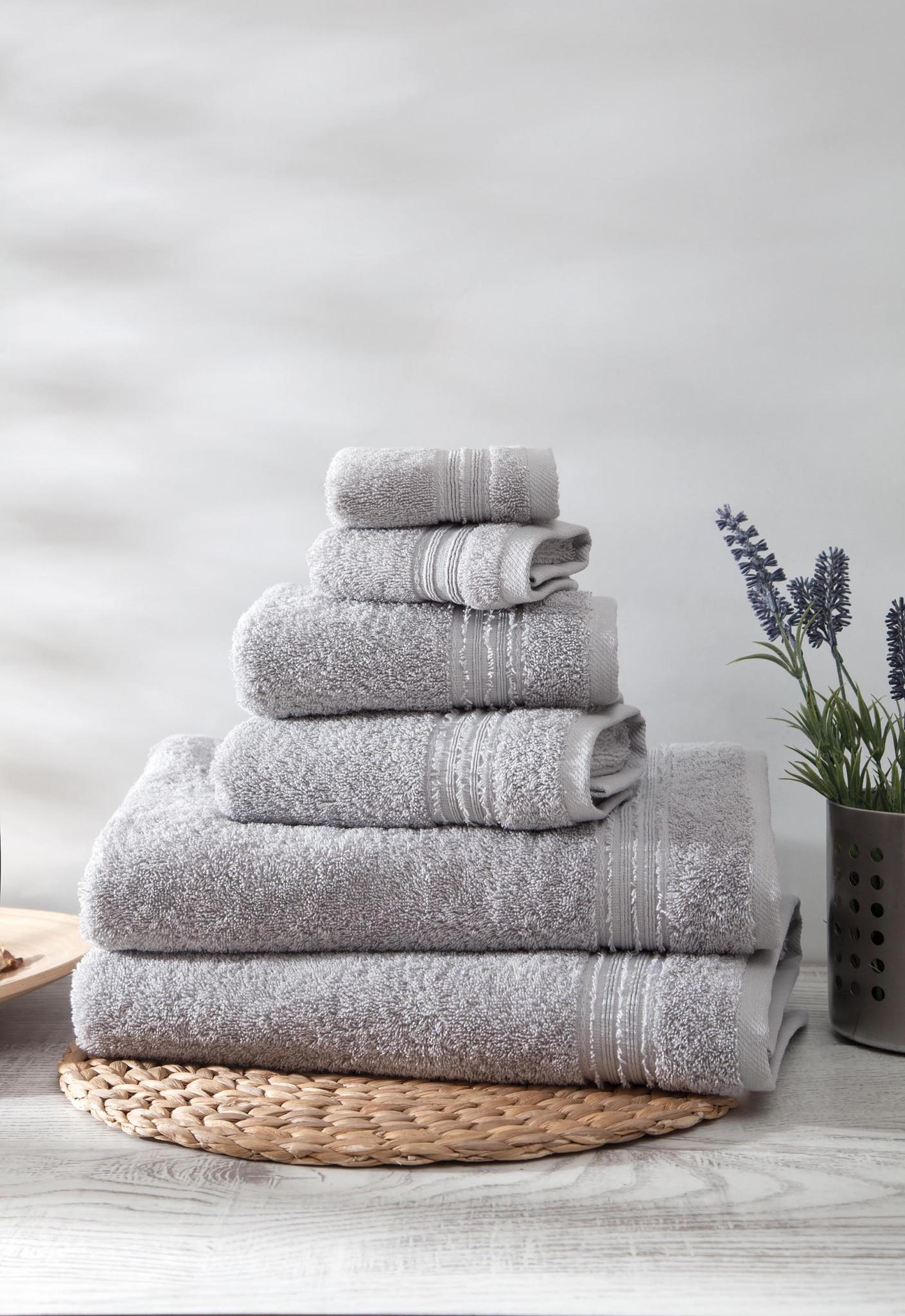 Set of six light gray Turkish cotton towels, folded stack with textured weave
