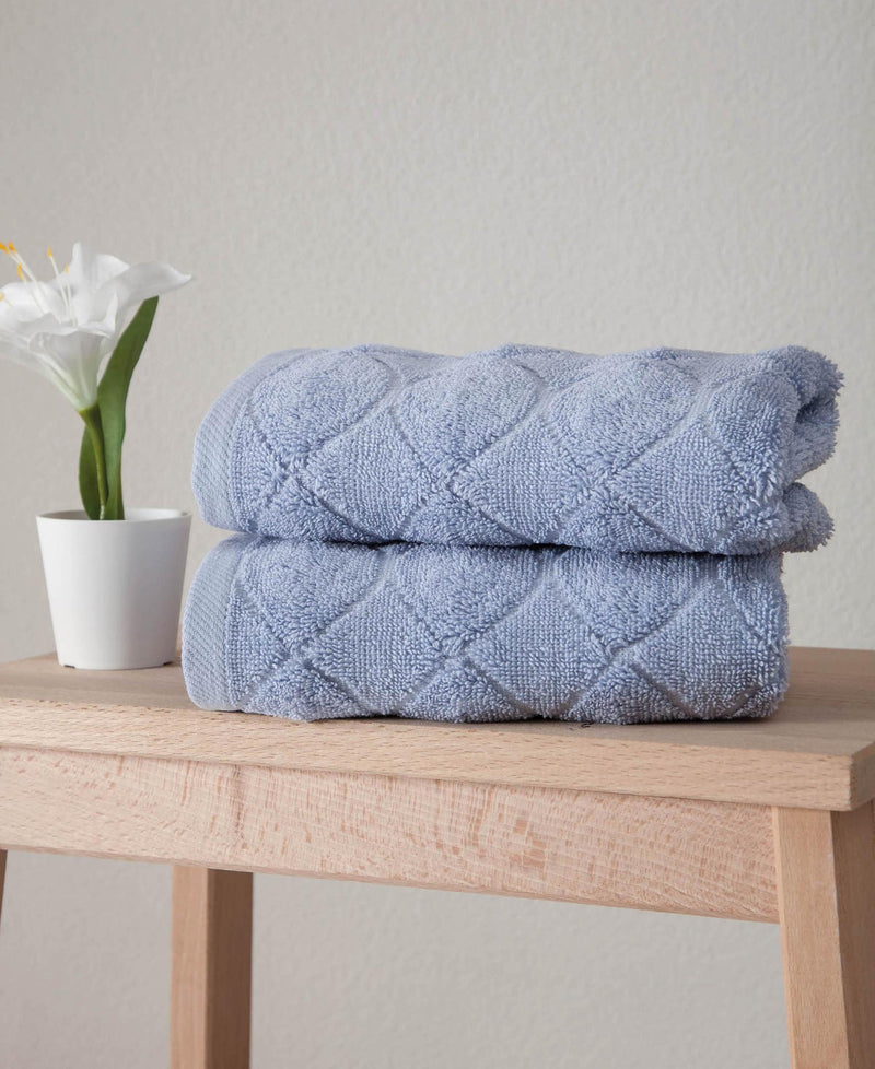 Blue geometric Turkish cotton hand towels, two folded on a stack