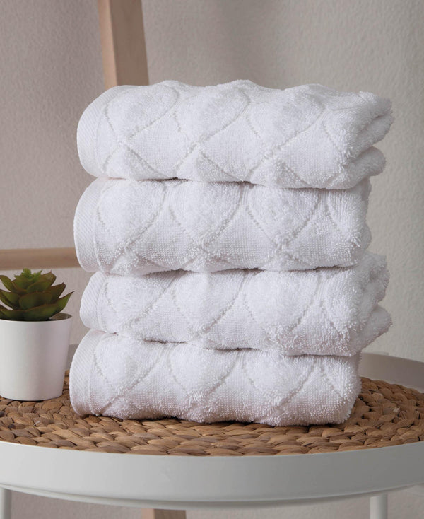 Set of four white Turkish cotton hand towels with geometric pattern, stacked