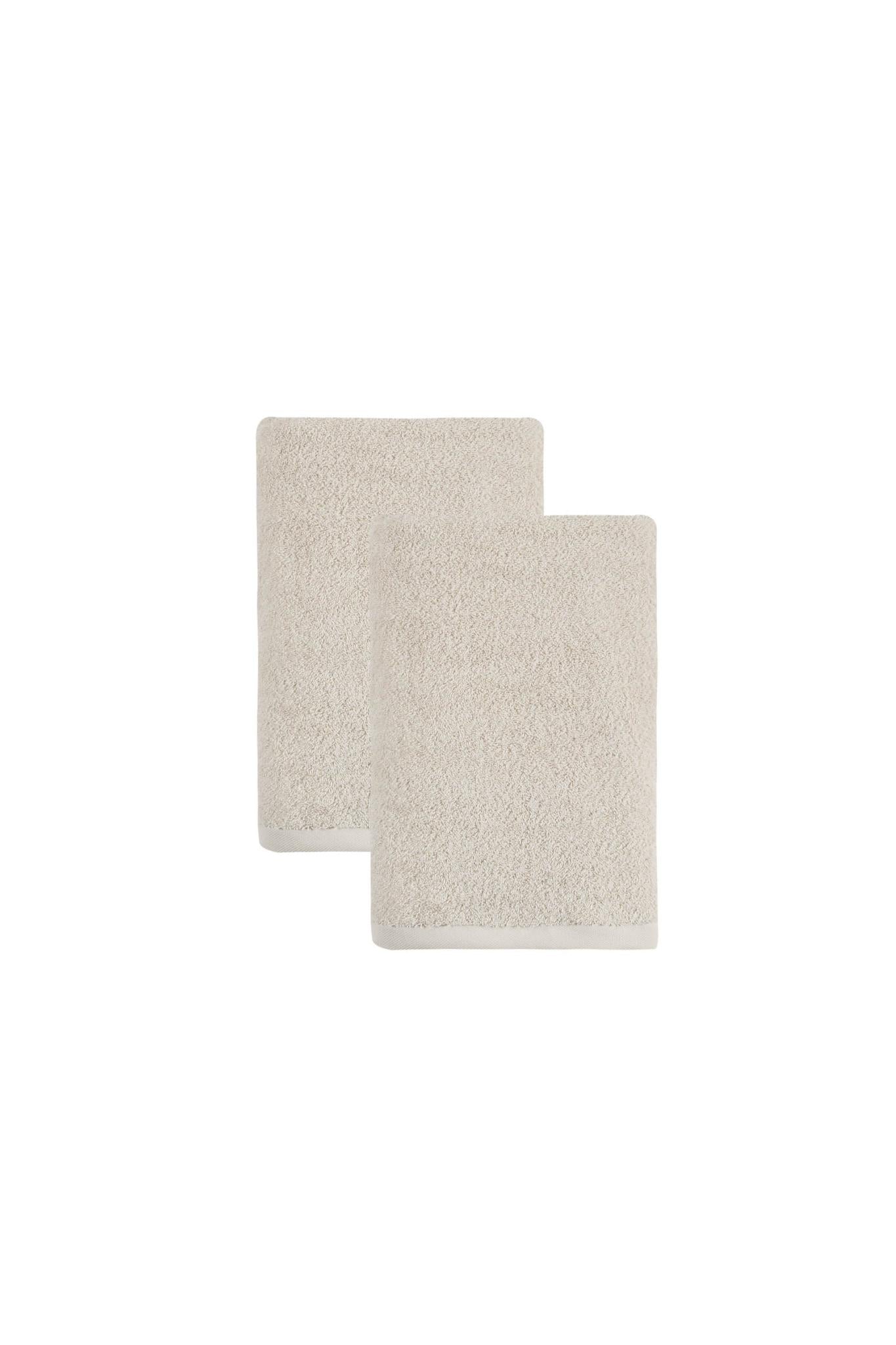 Set of two beige Turkish cotton bath towels, folded and stacked