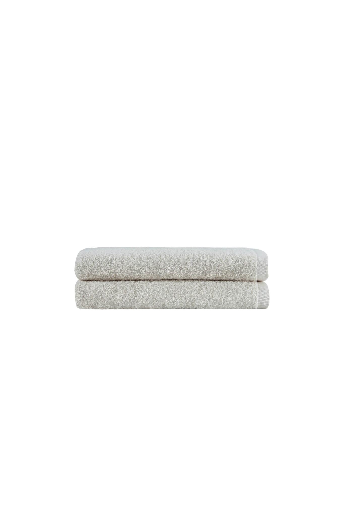 Set of two beige Turkish cotton bath towels, stacked in a neat pile