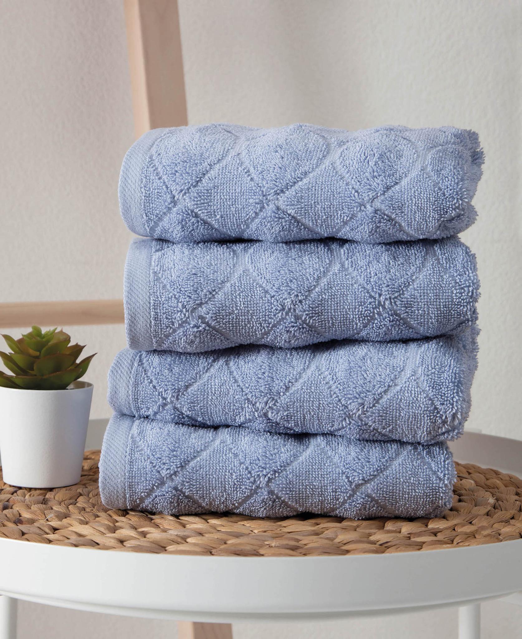 Set of four blue Turkish cotton hand towels, geometric pattern, stacked rolls