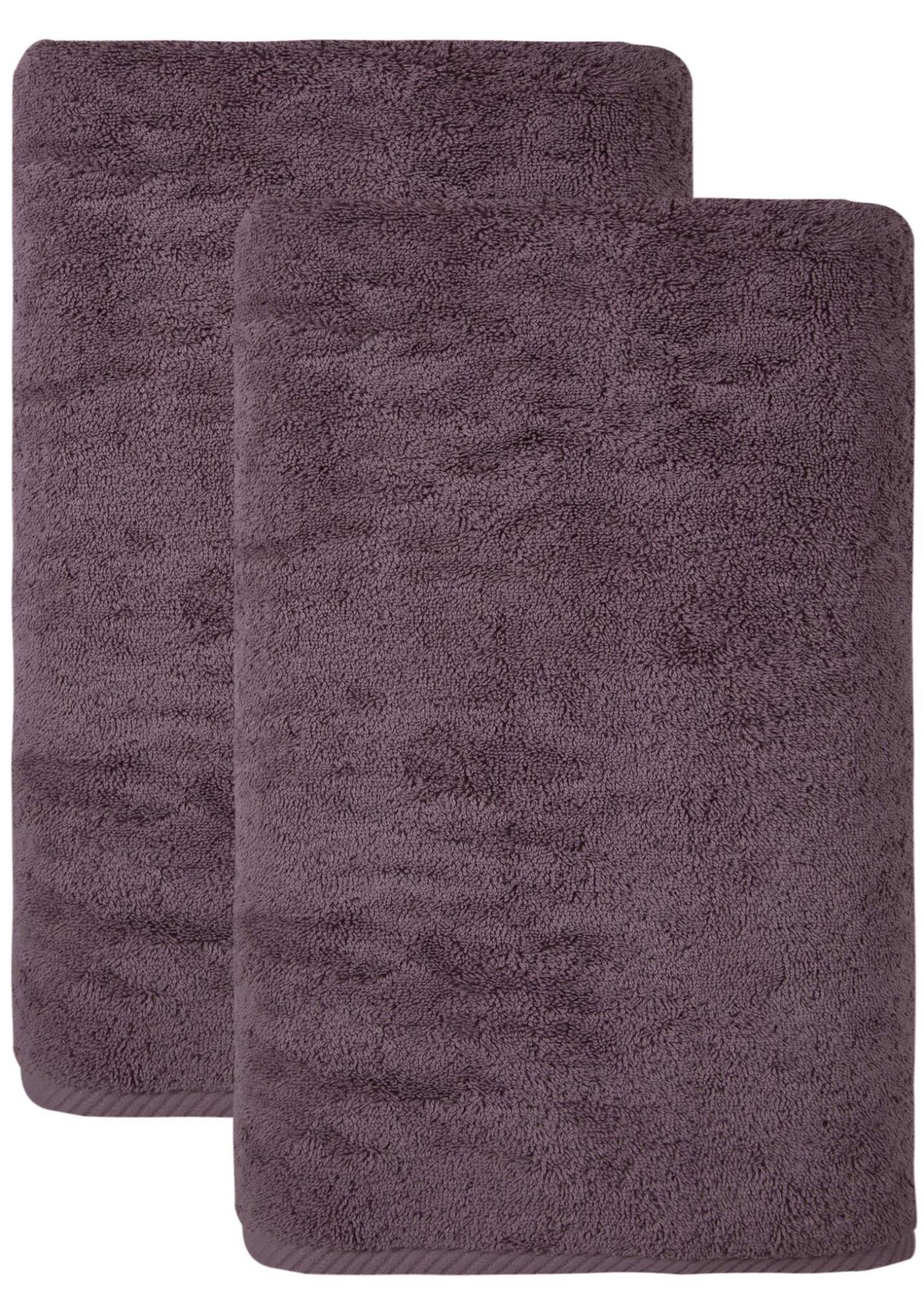 Purple Turkish cotton bath sheets, two folded towels with plush looped texture.