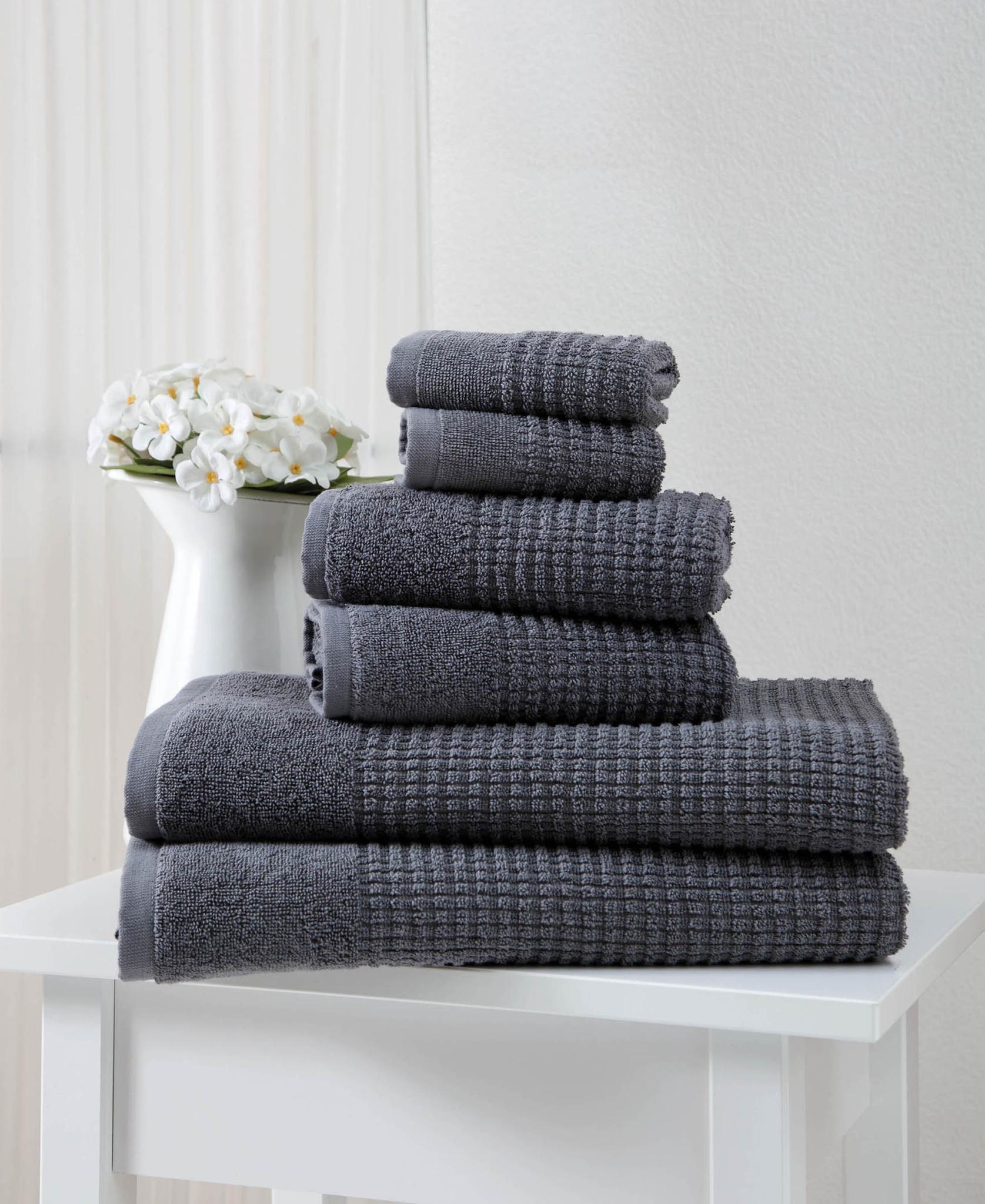 Set of six dark gray textured Turkish cotton towels, neatly folded stack