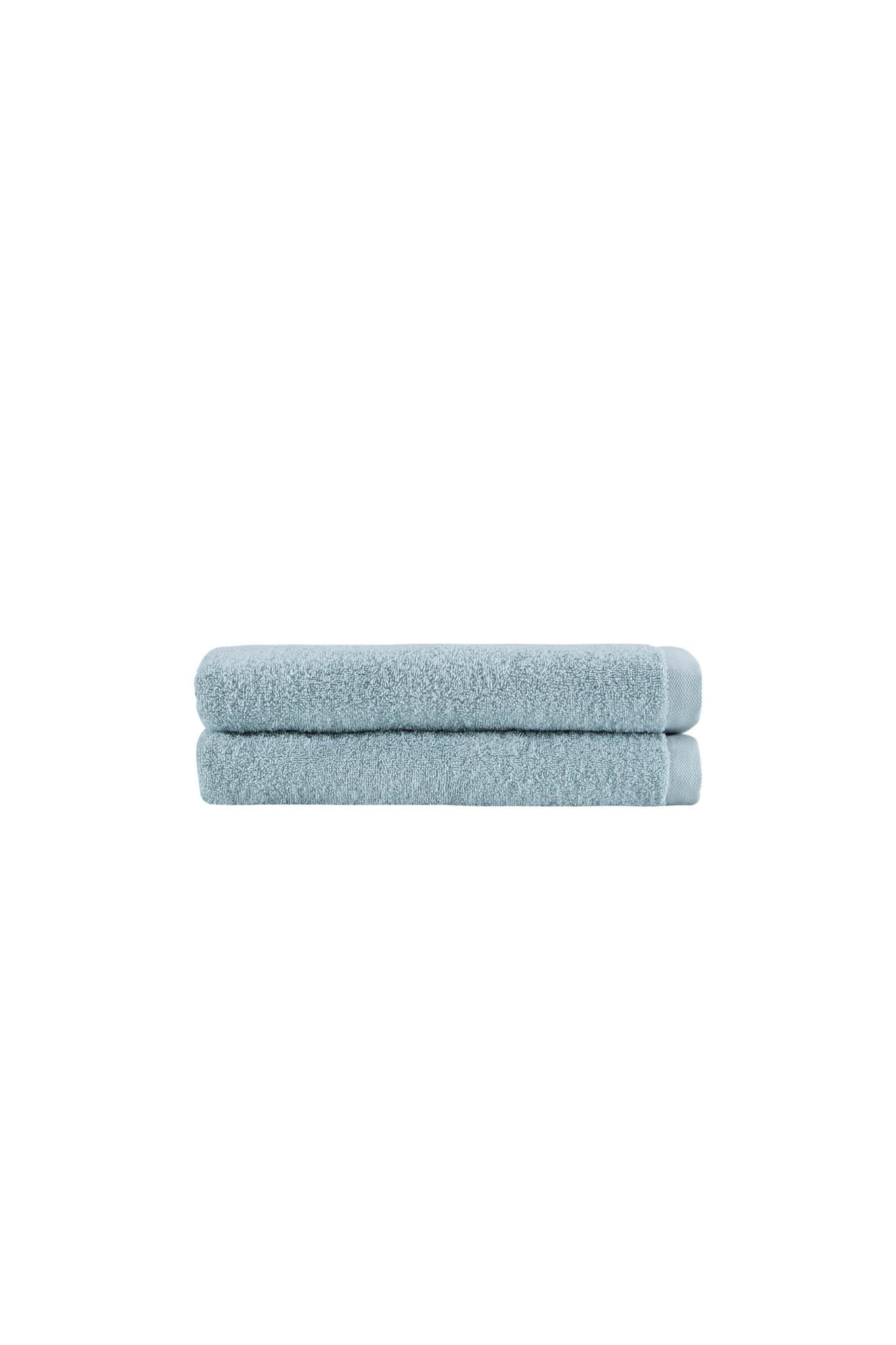 Set of two teal bath towels, neatly rolled