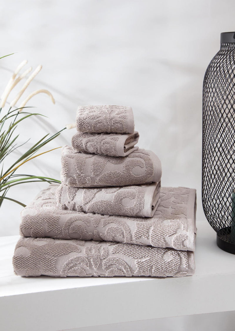 Light gray floral Turkish cotton towel set, neatly folded towels stacked on display.