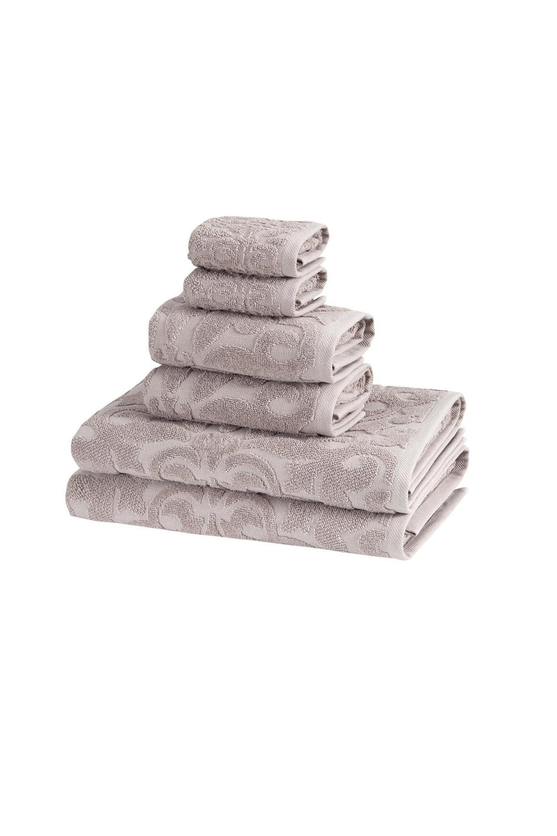Light gray floral Turkish cotton towel set, multiple folded towels stacked against white.