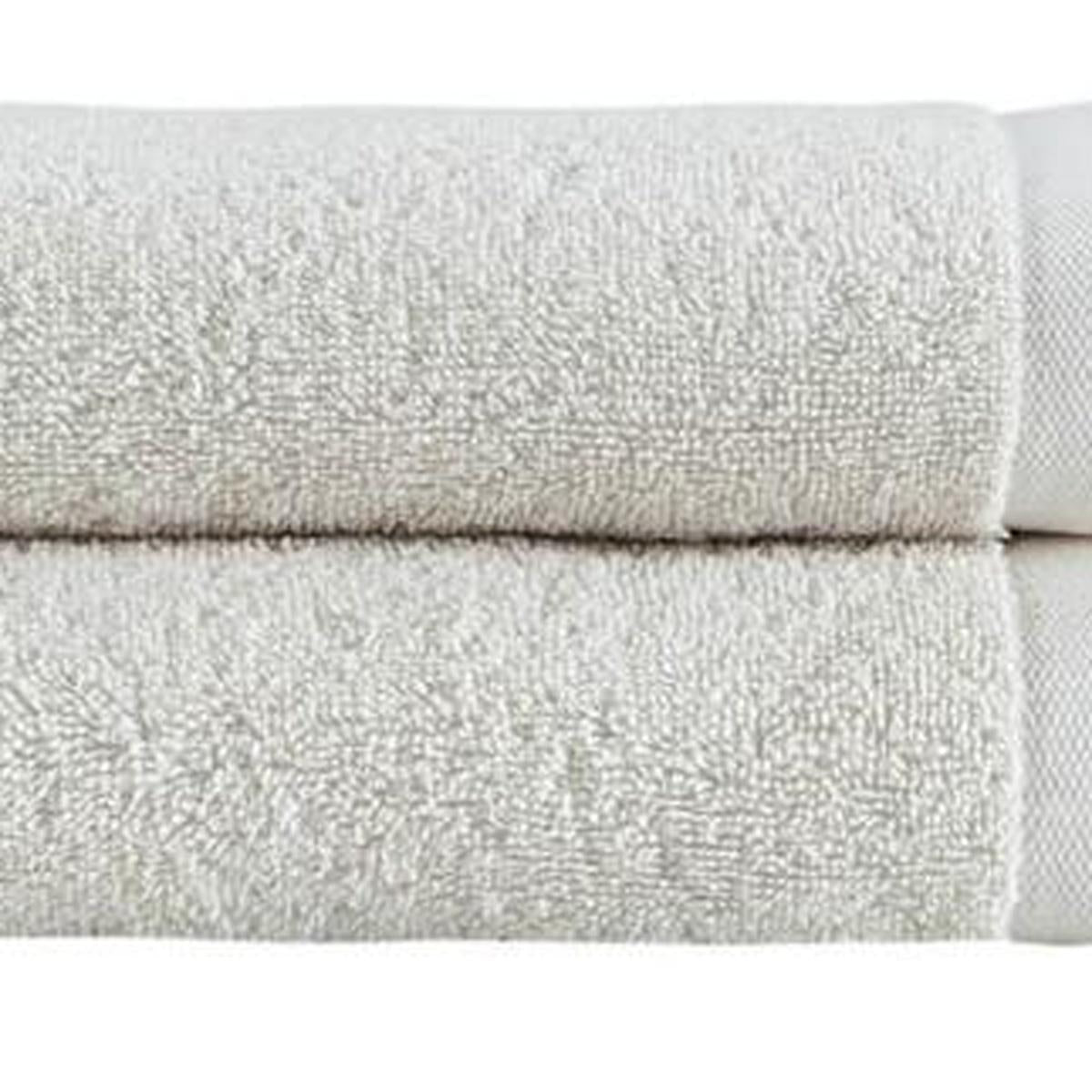 Close-up of beige hand towel texture with visible seam and folded hem