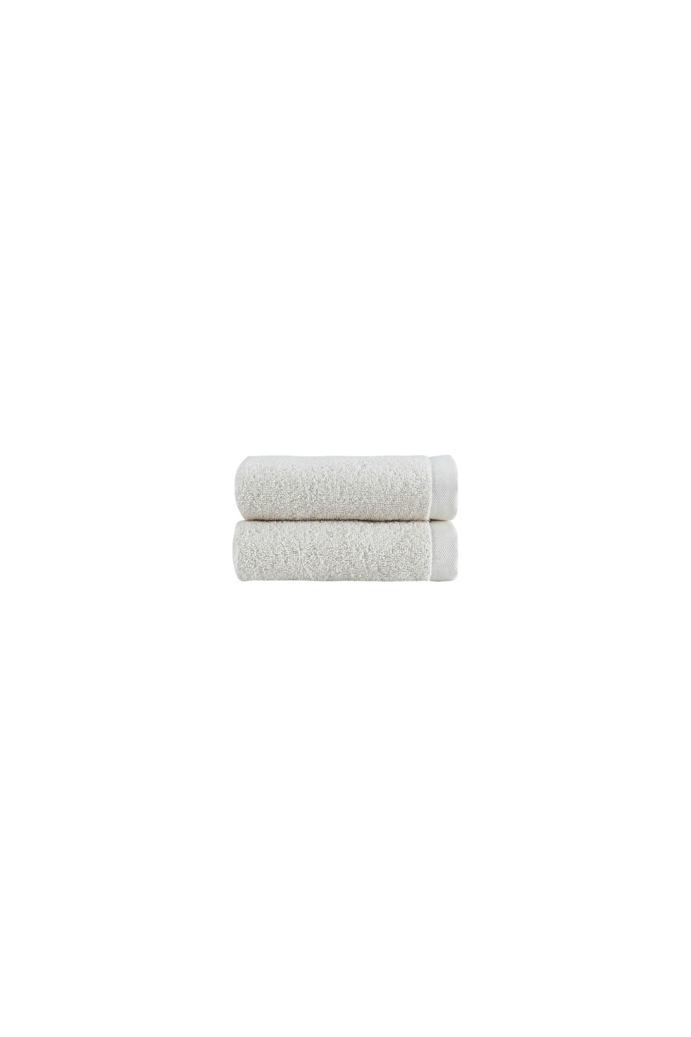 Two beige hand towels folded stack with textured cotton terry-like surface