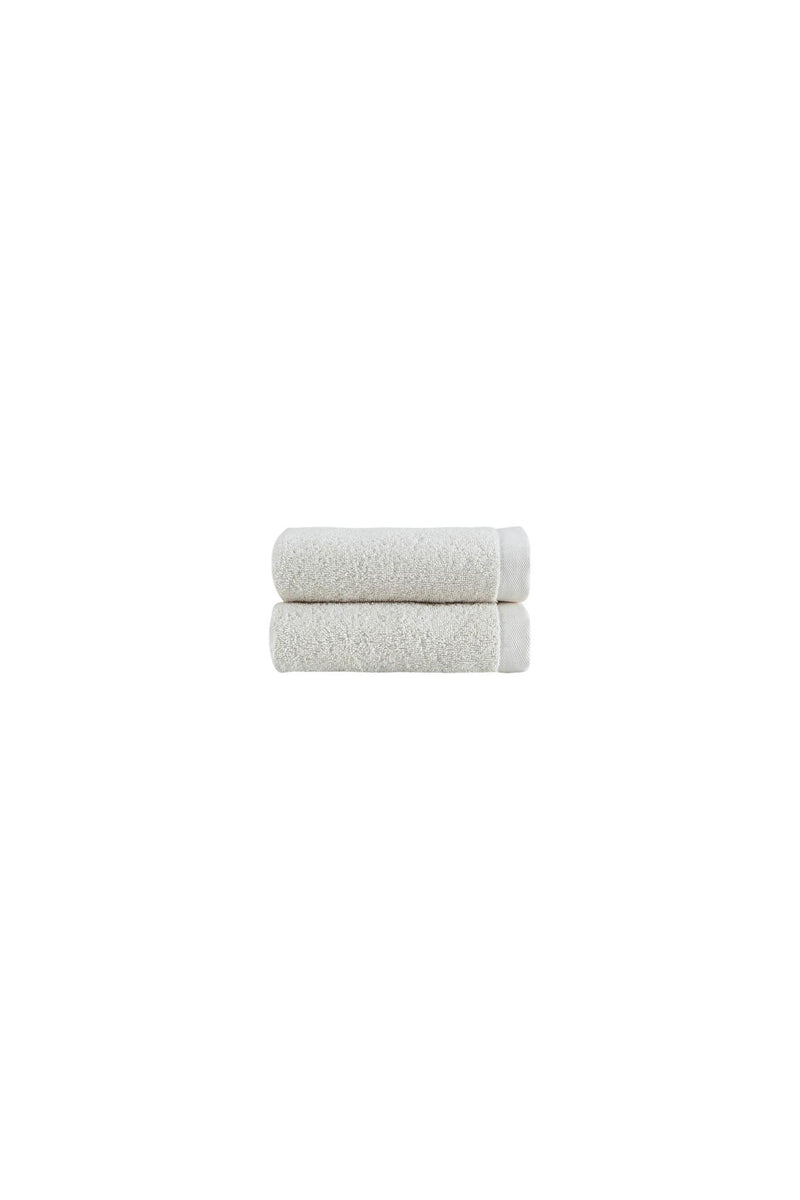Two beige hand towels folded stack with textured cotton terry-like surface