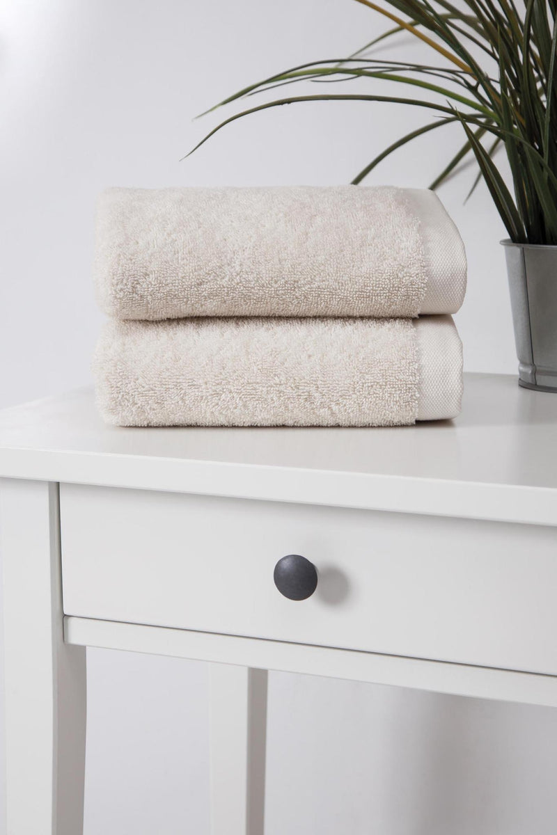 Set of two beige hand towels stacked and folded, soft textured cotton fabric