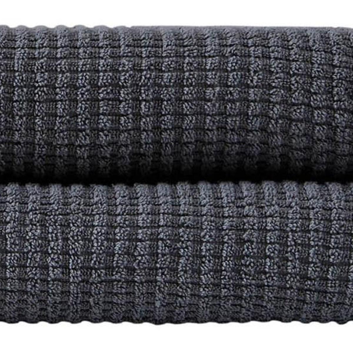 Dark gray bath towel fabric close-up with waffle-textured weave.