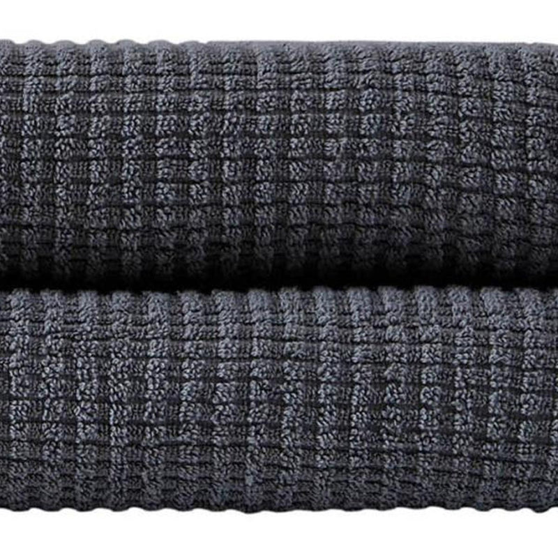 Dark gray bath towel fabric close-up with waffle-textured weave.